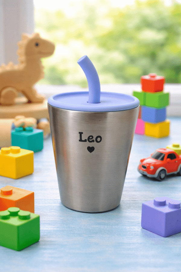 Personalized kids cup engraved with Leo, blue lid, surrounded by colorful toys