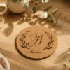 Personalised monogram cork coaster with floral letter A design and custom name Aarav on a warm wooden table
