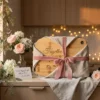 Personalised engraved bamboo chopping board wrapped with a pink ribbon and linen cloth, surrounded by flowers in a warm kitchen setting.