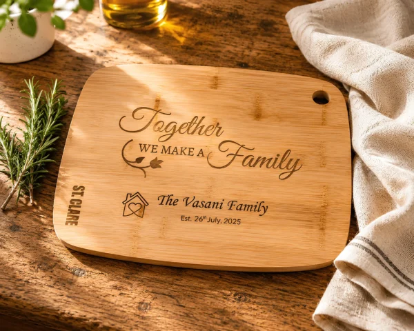 Personalised bamboo chopping board engraved with family name and special date on a rustic oak kitchen countertop with rosemary and linen cloth.